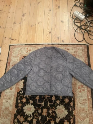 Grå/ blå  quiltad pufferjacka - Säljer den  grå/ blå trendiga  pufferjackan från Lindex , i storlek L,  är relativt liten i storlek , så ger mer en lite oversized snygg look 