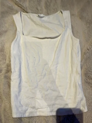 Vit linnetopp från Gina Tricot XS - Säljer en enkel och stilren vit linnetopp från Gina Tricot, kollektionen Basically Basics. Toppen är ärmlös med rak halsringning och tillverkad i mjuk bomull. Perfekt att matcha med jeans eller kjol för en clean look.