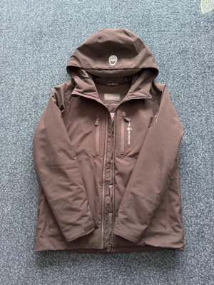Sail Racing Jacka - Sail Racing Patrol Jacket i svart färg. Storlek 160 cm. Snygg och praktisk jacka med huva och flera fickor.  I fint skick. Perfekt för kallare och blåsiga dagar!