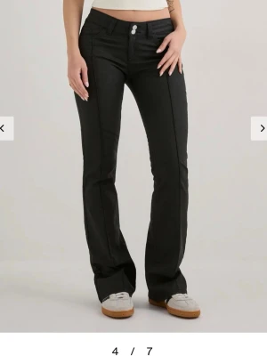 Svarta bootcut skinn byxor med låg midja - Snygga svarta skinn byxor med bootcut passform och låg midja. Endast använda 1-2 gånger så är som nya!! Från Nelly i storlek 32💓💓finns inte att köpa längre på hemsidan