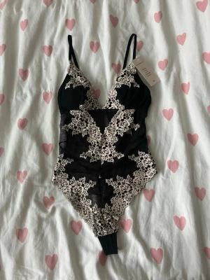 Svart spetsbody med blommig brodyr - Säljer en spetsbody i Intimissimi-stil. Storlek XS. Ny, med prislappen kvar. 🤍