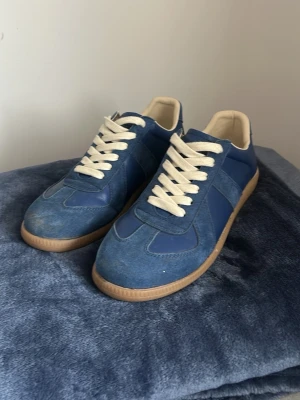 Blåa maison margiela gats - Säljer ett par snygga maison margiela gats!                                                                             Knappast använda, är tyvärr lite smutsiga men kan inte tvätta dem själv utan att förstöra dem                                                          Dem har storlek 41                                               Säljer dem eftersom jag inte har användning av dem!