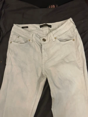 Ljusblå bootcut jeans med rå kant - Säljer ett par vita lågmidjade bootcut jeans. Är 168 och dom är för långa för mig därför lite missfärgade längst ner 