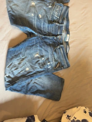 Replay jeans  - Säljer ett par blå jeans från Replay, modell Anbass. Jeansen har en slim fit passform och är tillverkade i denim med slitna detaljer, köpta för 2000kr på jenasbolaget. 