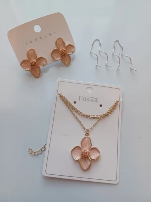 Jewelry set - 1) Baby pink flower earrings & necklace set.  Condition: Very good Colour: Baby pink Material: Stainless steel Brand: SheIn  2) Minimalist sterling silver spiral drop earrings  Condition: Very good Colour: Silver Material: Sterling silver Brand: Unknown (it was a gift)   Perfect for everyday or festive occasions.