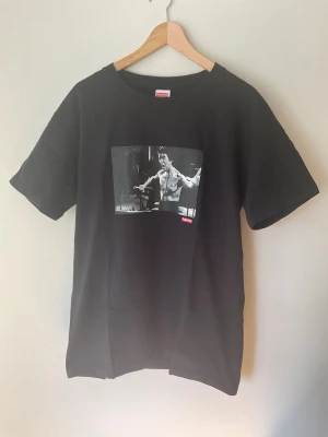 Bruce Lee Supreme T-Shirt - Size L - Bruce Lee Supreme T-Shirt. Size medium on tag, but fits like size large. Great condition, no flaws or damage. Size measurements are L - 72cm, W - 52cm. Buyer pays for all shipping costs. All items sent with tracking number.   No swaps, no trades, no offers.  No 100 questions from 14 year olds either, it’s a cotton tee, it’s cheap, buy it!