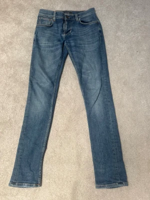 Blåa Nudie jeans - Ett par snygga ljus blå Nudie jeans i bra skickmed rak passform och snygg tvätt. Str W29 & L32. Hör av er om frågor 👍pris är inte hugget i sten.