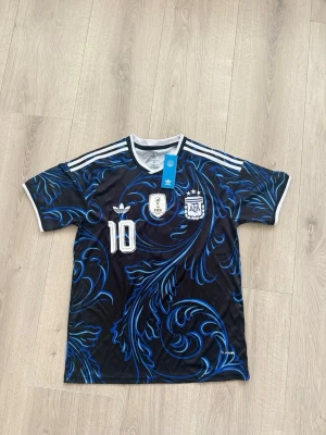 Argentina Messi matchtröja Adidas - Snygg svart och blå Argentina matchtröja från Adidas med Messi och nummer 10 på ryggen. Good quality och kommer med sin påse