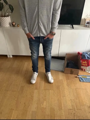 Jack & Jones jeans  - Säljer ett par blå slim fit jeans med lätt slitning och smal passform. Jeansen har klassisk femficksdesign och normal midja. Perfekta för dig som gillar en modern och enkel stil. Materialet är denim i bomull. Modellen är slim tim och storleken är 28x32 