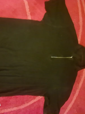 Svart hoodie från BOSS med halv dragkedja - Säljer en svart hoodie från BOSS med huva och halv dragkedja framtill. Hoodien har en enkel och clean design, perfekt för dig som gillar stilrena plagg. Tillverkad i mjukt material som känns skönt mot huden. Passar till det mesta och är lätt att matcha.