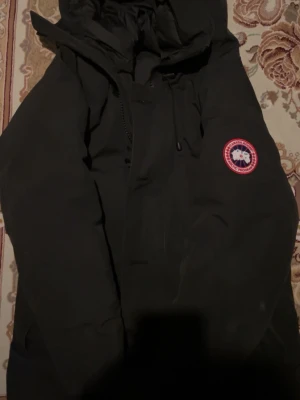 Svart parkas med pälskantad huva - Canada goose jacka med päls. Äkta jacka. Storlek M. Hör av er vid frågor.