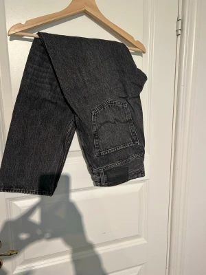 Svarta loose fit jeans - Säljer ett par svarta loose fit jeans med raka ben och klassiska bakfickor. Modellen heter LOOSE/CHRIS och de har en avslappnad passform som är perfekt för en chill och trendig look. Materialet är denim i 100% bomull.