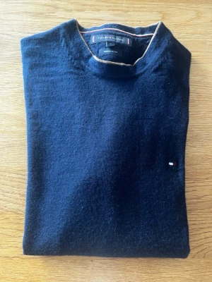 Mörkblå stickad tröja Tommy Hilfiger - Mörkblå stickad tröja från Tommy hilfiger 100% merinoull 