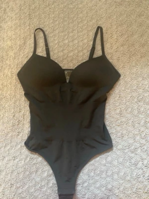 Svart body med tunna axelband - En svart supersnygg body från H&M aldrig använd bara testad. Passar de som är 170 cm långa🤍
