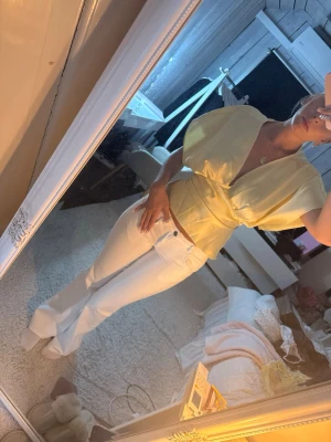 Vita lågmidjade jeans  - Säljer ett par vita jeans med rak passform och låg midja. Jeansen har klassiska fem fickor och stängs med knapp och dragkedja. Perfekta till sommaren och lätta att matcha med olika toppar.