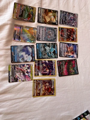 Samling Pokémonkort Fullart - Säljer en samling Pokémonkort med flera V- och GX-kort. Korten har färgstarka illustrationer och holografiska effekter. Blandade motiv med olika Pokémon och attacker. Perfekt för dig som vill utöka din samling eller spela TCG.