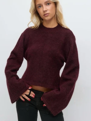 Vinröd stickad tröja med vida ärmar - Mysig vinröd stickad tröja med rund hals och extra vida ärmar. Tröjan har en något croppad passform och är tillverkad i ett fluffigt, mjukt material som ger en trendig look. Perfekt för dig som gillar en avslappnad men stilren stil.