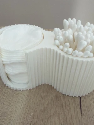 Vit förvaringsbox för bomullpads och tops - Praktisk vit förvaringsbox i plast för bomullspads och tops. Snygg vågig design som håller ordning på dina skönhetsverktyg på sminkbordet eller i badrummet. Perfekt för att snabbt komma åt pads och tops när du sminkar dig eller tar bort smink.