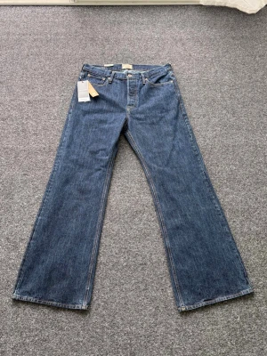 Helt nya! Flared jeans! W32-L34  - Snygga blå jeans från Jack & Jones med raka, vida ben och klassisk femficksdesign. Jeansen har normalhög midja och är tillverkade i slitstark denim. Perfekta för en avslappnad och trendig look.