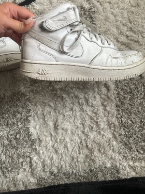 Vita Nike Air Force 1 High  - Höga versionen av Air Force 1 Nile sneakers. De är synligt använda och sänker pris om det önskas. Har putsat lite på dem men går nog att fixa mer. Skosnören är lite slitna men går ju att byta ut. Har lite repor och skador pga användning. Skicka prisförslag 🙏 Skulle nog säga att största defekt är snörerna :( Byta till nya så får dem en glow up 