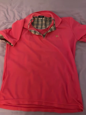 Rosa pikétröja med rutigt foder - Den är XXL men känns lite som L eller M. Säljer den pga jag inte passade i den 