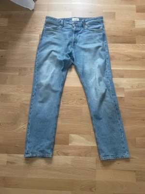 Ljusblå relaxed jeans Jack & Jones  32 32 - Säljer ett par ljusblå relaxed fit jeans från Jack & Jones. Klassisk femficksmodell med raka ben och normal midja. Tillverkade i slitstark denim med snygg tvättad look. Perfekta för en avslappnad och trendig stil.