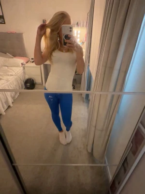 Blå peach tights - Säljer ett par blå peach tights med hög midja och tight passform. De är stretchiga och sitter snyggt längs benen. Perfekta till träning eller chill. 