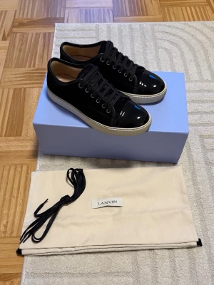 Lanvin DBB1 Patent Cap Toe - Säljer mina Lanvins i storlek 40 men sitter som en rymlig 41. Svarta med glansig tå. Skorna är i mycket fint skick utan skavanker. Har tagits väl hand om. Köpta från Care of Carl för cirka 6 månader sedan och använda varsamt, främst på jobbet (kontorsjobb). Dustbag och extra skosnören medföljer. Hör gärna av dig om du är intresserad!
