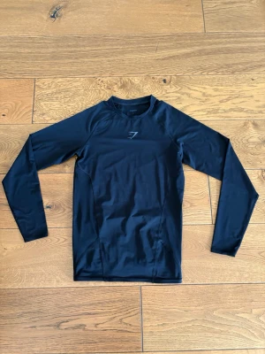 Svart compression shirt Gymshark - Tight svart compression shirt från Gymshark med diskret logga på bröstet. Perfekt till gymmet.