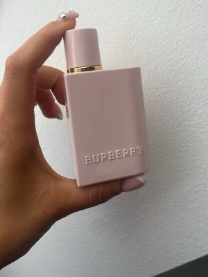 Burberry her intense rosa parfymflaska ca 50% kvar i flaskan  - Säljer en stilren parfym från Burberry i en ljusrosa, matt flaska med gulddetalj vid halsen. 