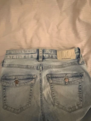 Ljusblå jeans från Stradivarius - Säljer ett par ljusblå jeans från Stradivarius med raka ben bakfickor. Jeansen är tillverkade i mjukt denimtyg. 