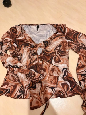 Brun blus topp strl S - Säljer en brun och beige swirlmönstrad blis från Newyorker. Strl S och knappt använt endast ca 4 gånger. 
