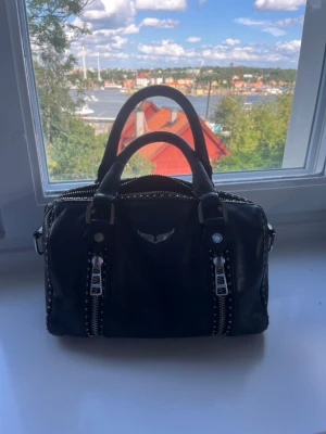 Zadig väska - Säljer denna super fina Zadig väska! Den är väl använd och har tyvärr en ”knapp” borta på baksidan (se näst sista bilden) och är även ganska ”rostig” på en del ställen. 100% äkta, dustbag och oanvänt band till väskan tillkommer också! Perfekt väska till vardagen som får plats med mycket mer än man tror 🥰