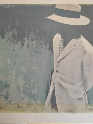 Inramad konstbild med man i hatt - Säljer en inramad konstbild som föreställer en man i ljus kostym och hatt mot en blågrön bakgrund. Bilden har en stilren, modern känsla och ramen är i metall med ljus passepartout. Perfekt för dig som gillar unik väggkonst. Där e autograf på den.