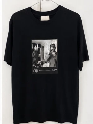 Limitato t-shirt - Svart Limitato t-shirt med ett stort svartvitt fototryck på bröstet. T-shirten har rund hals och korta ärmar, och är tillverkad i mjuk bomull. Perfekt för dig som gillar stilrena plagg med en cool detalj framtill.