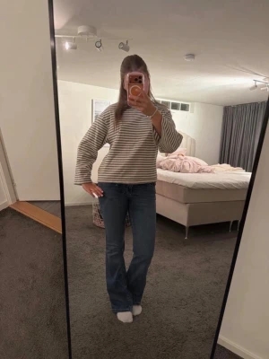 Blå bootcut jeans med broderade fickor - Säljer ett par blå bootcut jeans med snygga broderade detaljer på bakfickorna. Dem har endast en liten slitning ner svid benet som visas på bilder annars är dem som helt nya. orginalpris 600