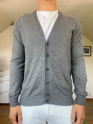 Grå Kashmir cardigan  - Grå cardigan tillverkad i bomull och kashmir från Massimo Dutti. Strl S. Inga defekter. Modellen är 178 cm och väger 77 kg. Hör gärna av dig vid frågor!