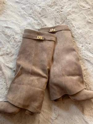 Beige boots  - Snygga beige stövlar i mocka med guldfärgade spännen upptill och dragkedja. Använda 1 gång.