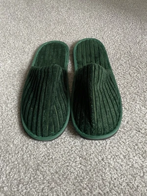 Enkla ribbade tofflor i färgen mörkgrön - Tofflorna är 26 cm vilket motsvarar ca storlek 37-38 EU helt nya✅ Inpacketerade✅ Snygga✅😉 Det finns flera par i lager, önskas det mer än ett par tofflor så är det bara att säga till!