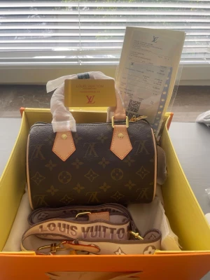Louis Vuitton Speedy 20 – Bandoulière - Säljer en superfin Louis Vuitton Mini Speedy 20 i klassiskt Monogram-mönster 🤎  Väldigt stilren och populär modell som passar perfekt till både vardag och finare tillfällen. Väskan är kompakt men rymmer det viktigaste. Det här är min mammas väska som hon fick i 50 års present som jag nu säljer.  📦 Skick: [Helt ny] ✨ Modell: Mini Speedy 20 🤎 Färg: Monogram 📸 Fler bilder kan skickas vid intresse.  Hör gärna av dig om du har några frågor!