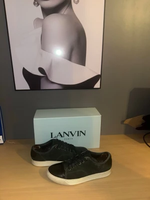  Lanvin  - Säljer dessa Snygga ovanliga sneakers från Lanvin . Skorna har vita sulor och grön mocka. Klassisk låg modell som passar till många olika stilar. Kommer med originalkartong. Använt sick men ser väldigt fräsch ut lite slitna skosnören och inne vid hälen men inget som märks av. Sickar även med ett par andra skosnören som kan sättas på annars finns de väldigt liknade att köpa i andra butiker. Hör av er vid frågor. Storlek 43-uk9