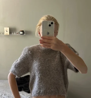 Beige fluffig stickad kortärmad tröja - Mysig och fluffig stickad tröja i beige med korta ärmar och rak passform. Tröjan har en något croppad längd och rund halsringning. Pris går att diskutera.