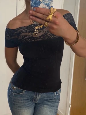 Svart offshoulder topp med spets - Snygg svart offshoulder topp med spetsdetaljer upptill. 