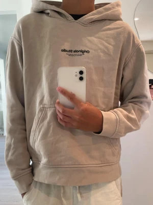 Beige hoodie från Jack & Jones - Säljer en beige hoodie från Jack & Jones med trycket 'original studio' på bröstet. Perfekt skick. Redo för en ny användare!