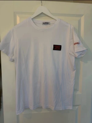 Vit Burberry t-shirt med tryck - Säljer en vit t-shirt från Burberry i storlek L. Inga skador eller defekter. 