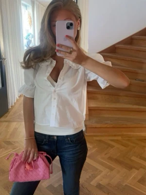 Rosa flätad handväska med axelrem - Trendig rosa handväska i flätad design med justerbar axelrem. Väskan har en mjuk, puffig form och stängs med dragsko. Perfekt för dig som vill ha en färgklick till din outfit. Tillverkad i konstläder med snygg finish.