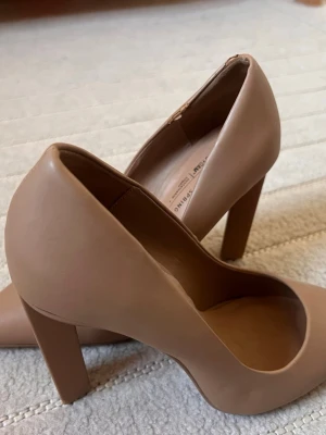 Beige pumps med chunky klack - Snygga beige pumps från Call It Spring med chunky klack och rundad tå. Skorna är tillverkade i veganskt material och har en bekväm innersula med B.E.D Foam. Perfekta för dig som vill ha både stil och komfort. Den har lite repor på vänster skor.