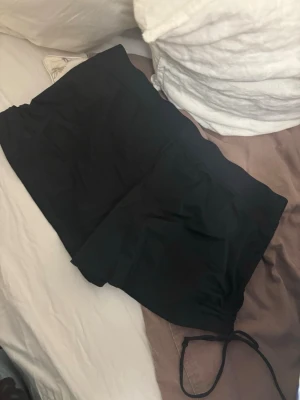 Svarta badshorts från bonprix - Säljer ett par svarta badshorts från bonprix. De har en enkel och klassisk design med dragsko i midjan för justerbar passform. Materialet känns lätt och snabbtorkande, perfekt för stranden eller poolen.