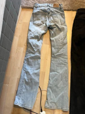 Ljusblå och svarta bootcut jeans - Säljer ett par ljusblå jeans med bootcut-modell och klassiska fem fickor. Jeansen har låg midja och är tillverkade i ett mjukt denimtyg. Perfekta för dig som gillar retrovibbar och vill ha ett par riktigt snygga jeans till din garderob. 300 för båda tar bud