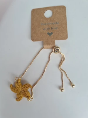 Armband med gyllene sjöstjärna - Unikt armband med reglerbar, guldfärgad kedja och en senapsgul, lätt skimrandel sjöstjärneberlock. Gjort för hand av mig i polymerlera. 